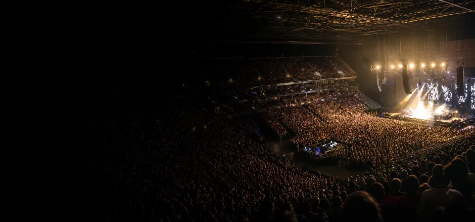 A capacity crowd watching a live concert in a major arena
